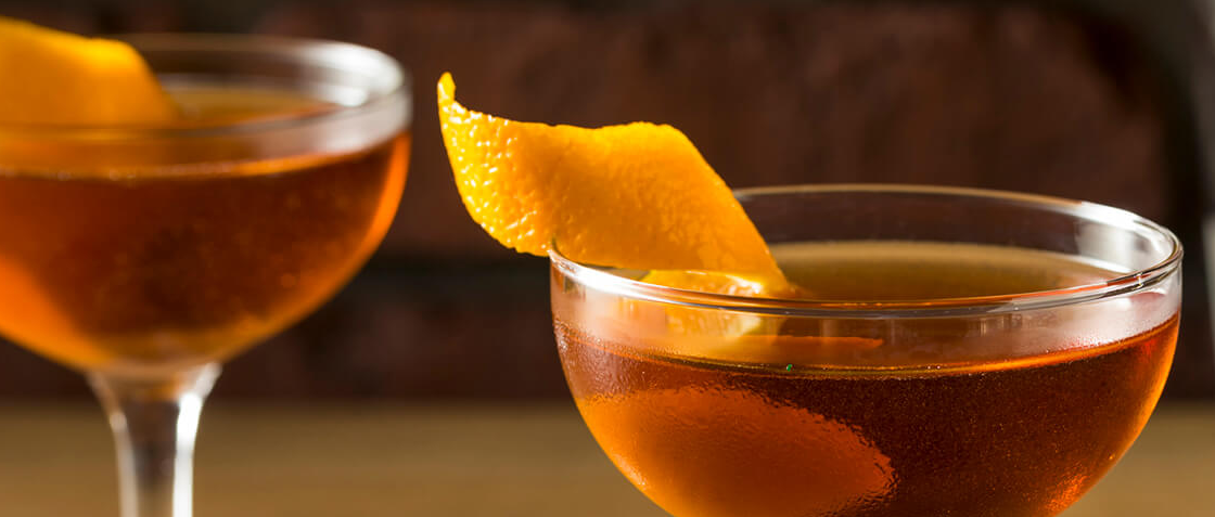 Cóctel Americano servido en vaso bajo con hielo y rodaja de naranja