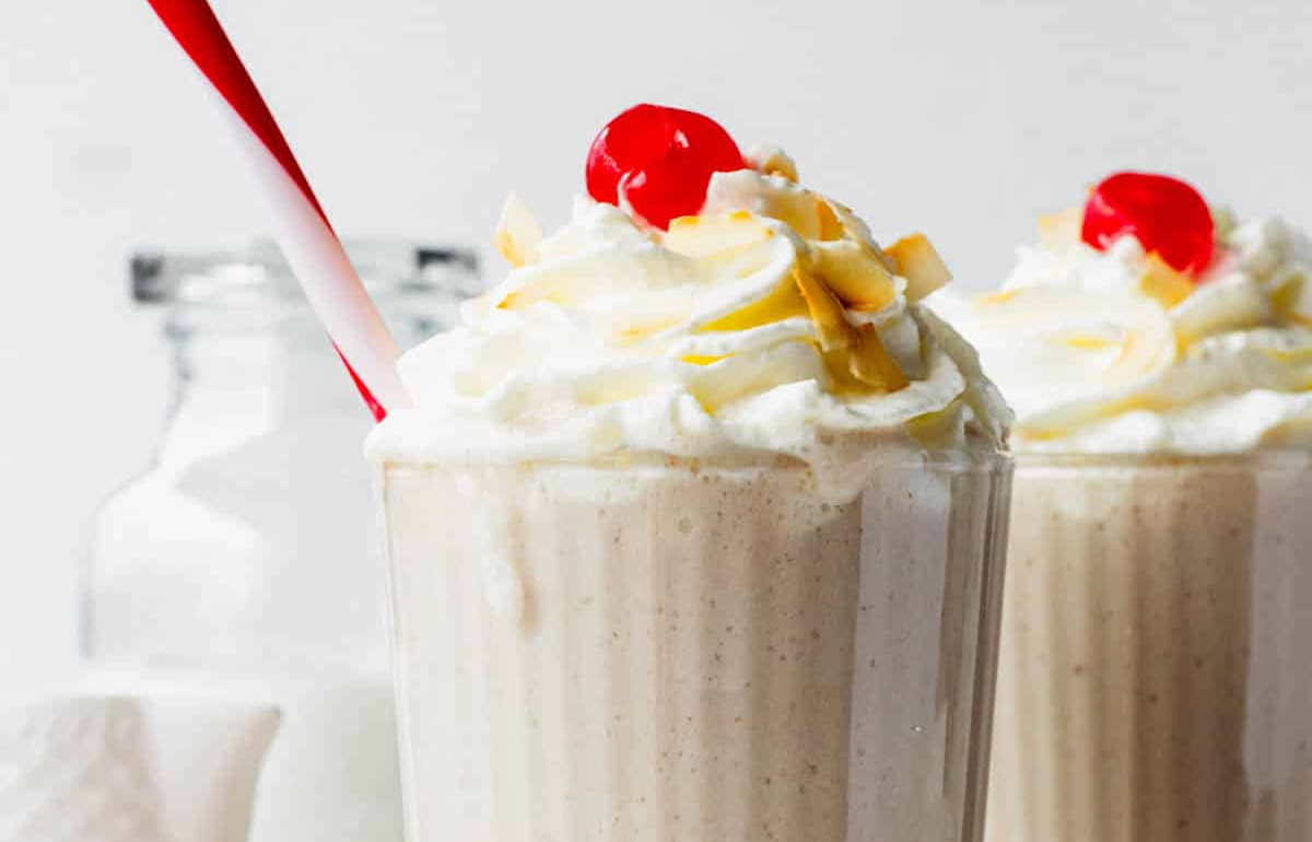 Batida de coco brasileña servida fría en vaso con coco rallado