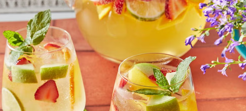 Sangría blanca servida con frutas claras y vino blanco en jarra fría