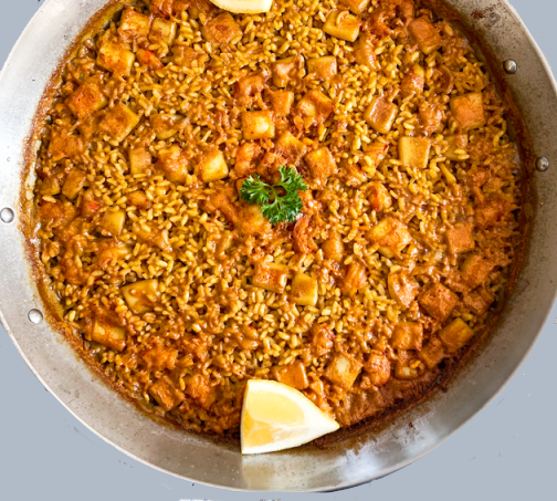 Arroz a banda servido tradicionalmente en paellera con marisco alrededor