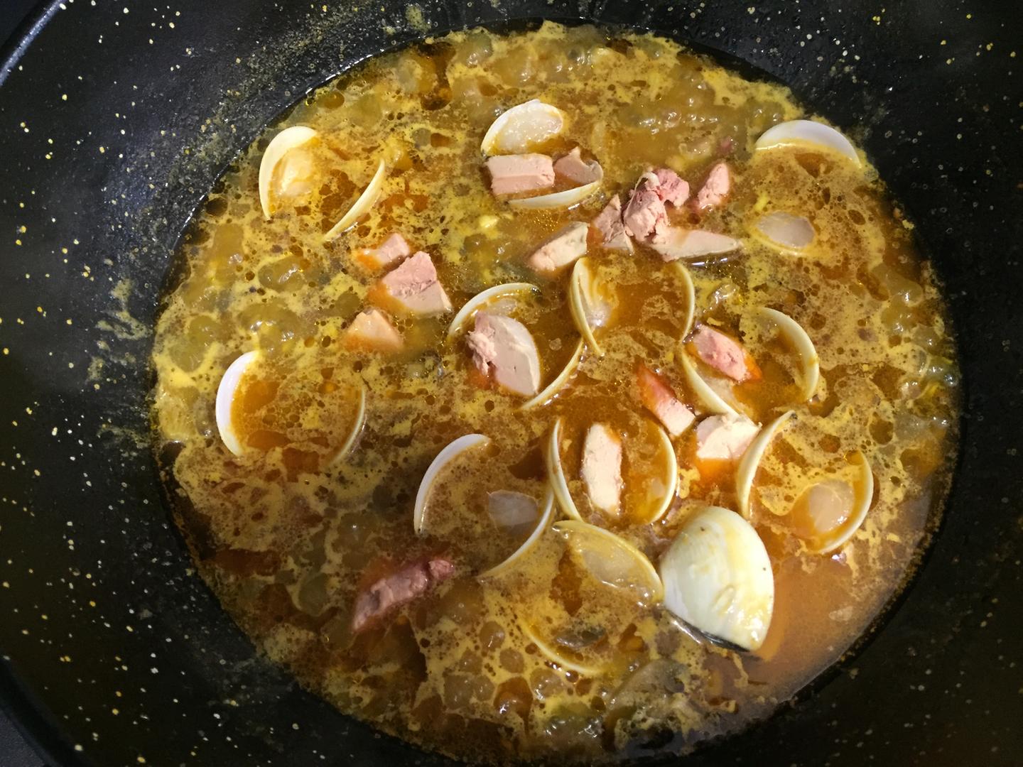 Añadiendo almejas y foie al arroz