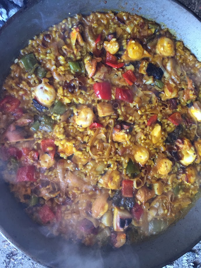 Paella de pulpo con ajos tiernos sobre paellera