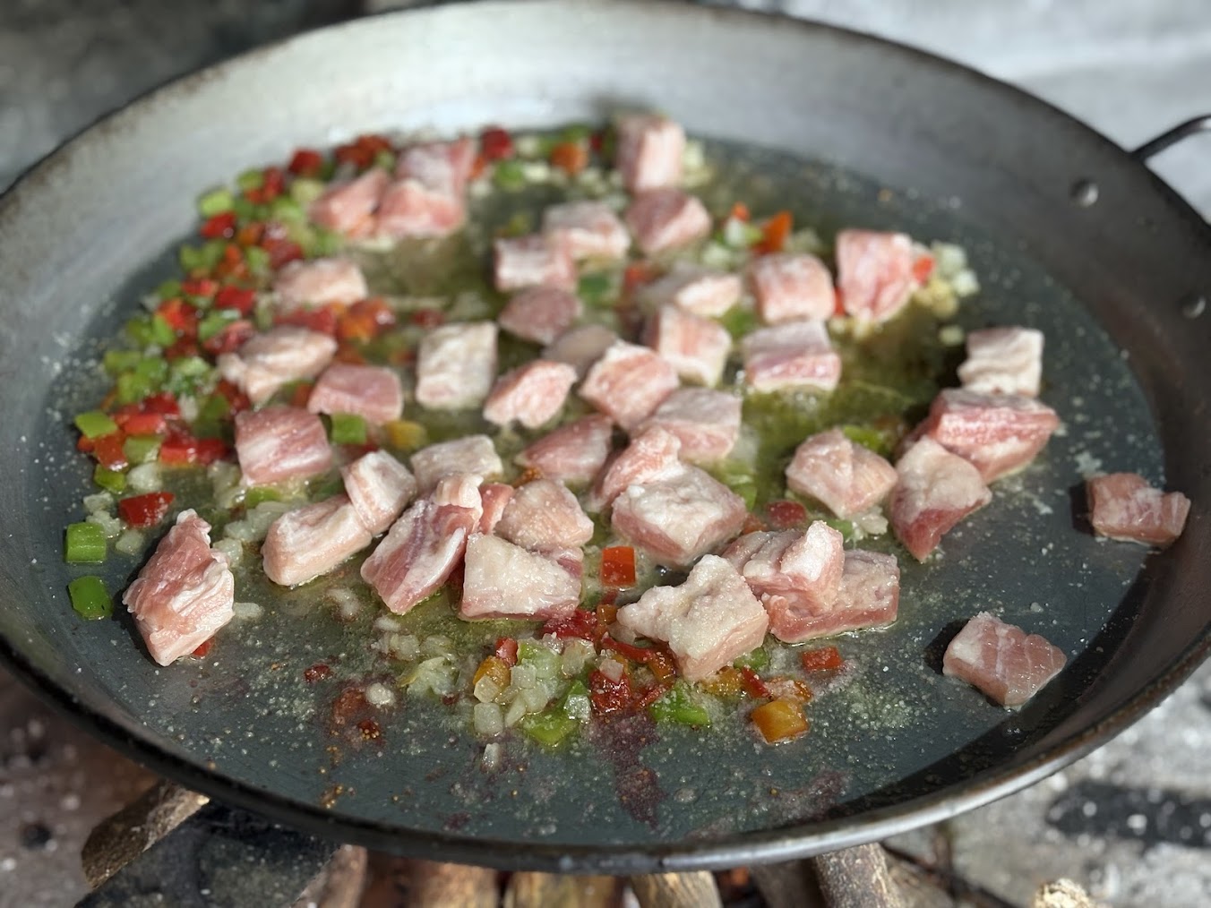 Secreto con cebolla y pimientos sofriéndose