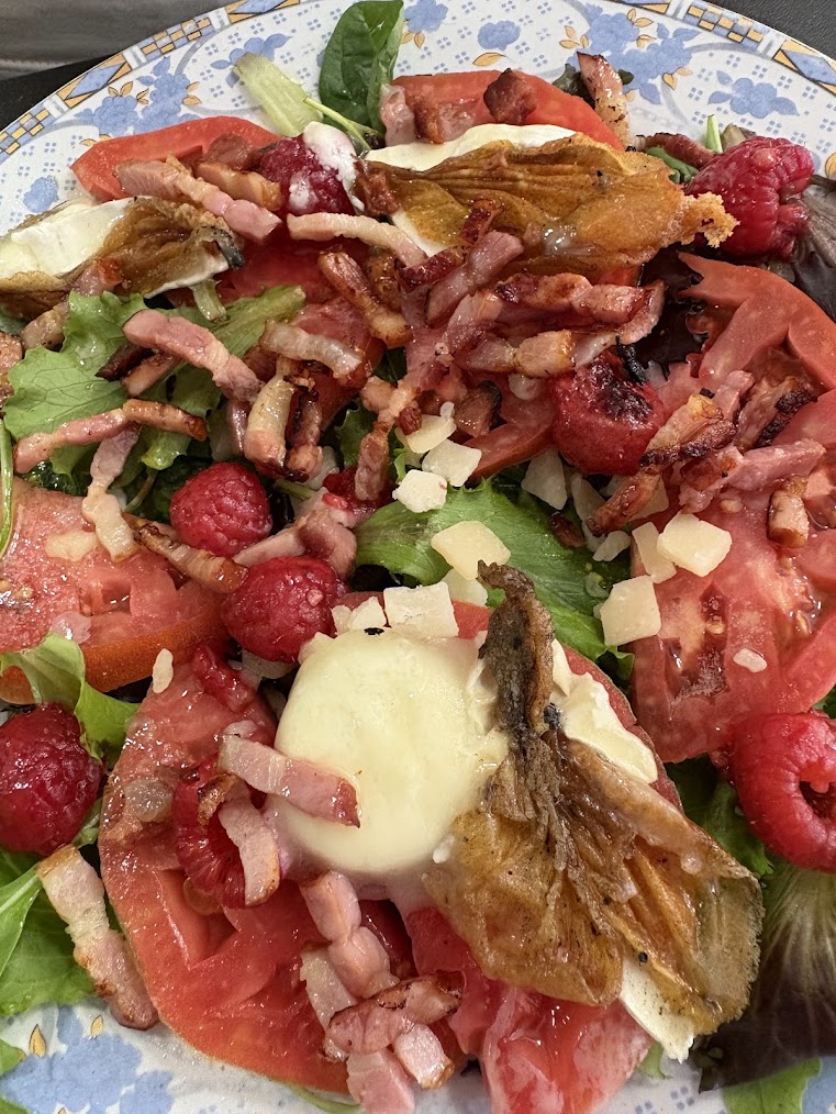 Ensalada templada de cabra, bacon y frambuesas emplatada