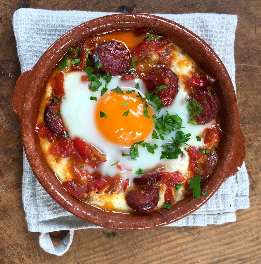 Huevos al plato con salsa de tomate y jamón