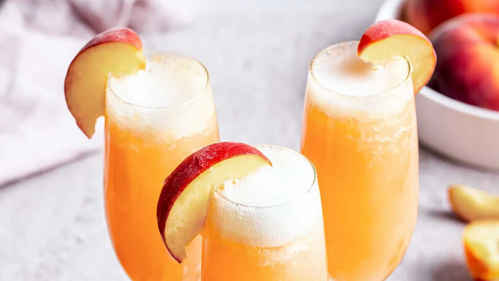 Copas de Bellini de color melocotón con burbuja fina