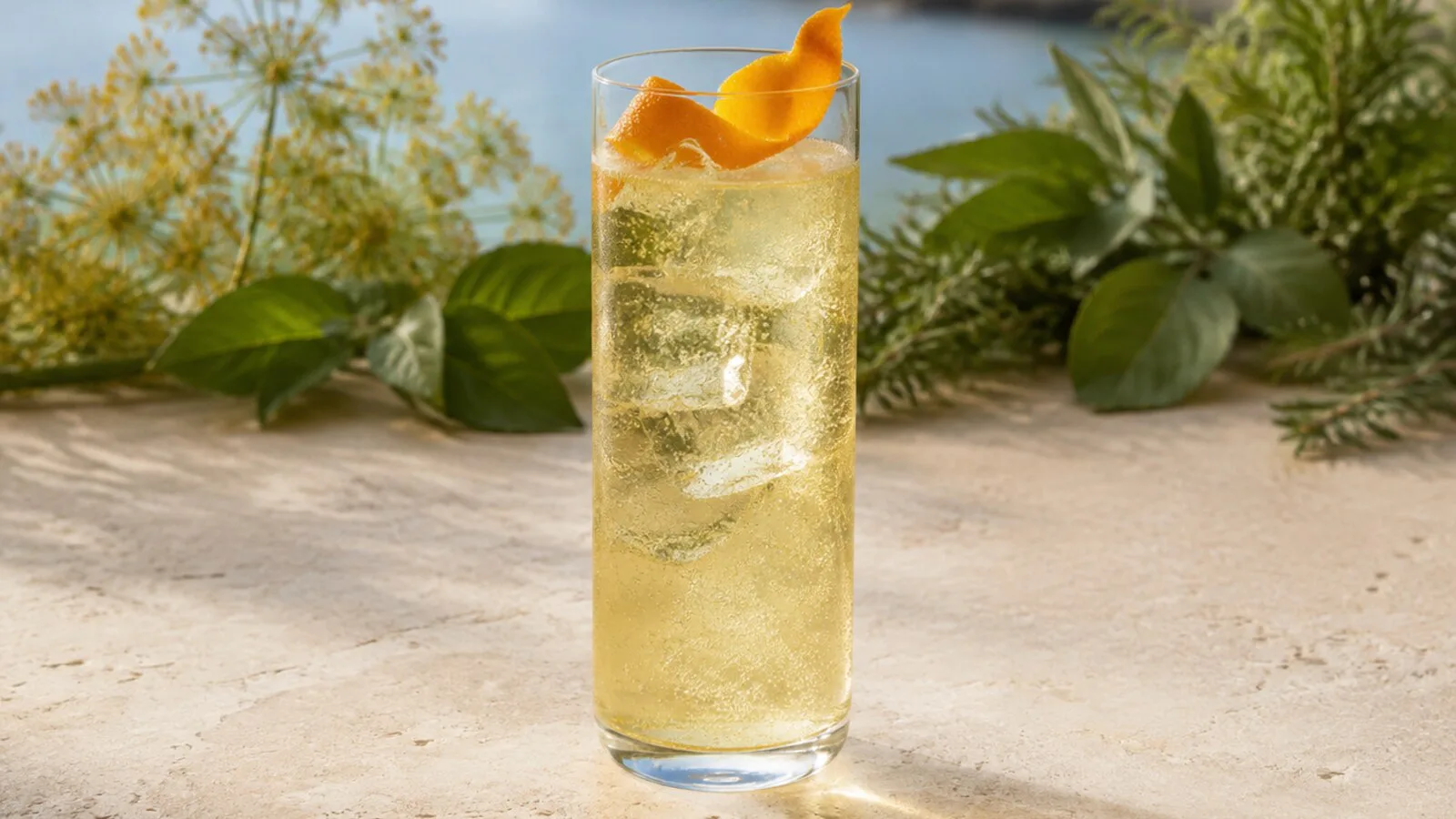 Hierbas de Mallorca con soda, hielo y piel de naranja en vaso alto