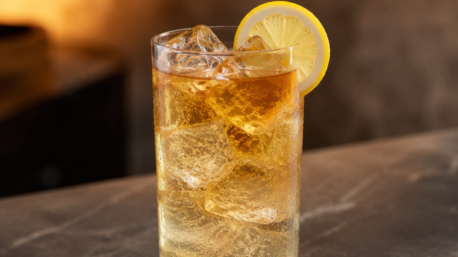 Long Island Iced Tea color ámbar con hielo, cola y una rodaja de limón
