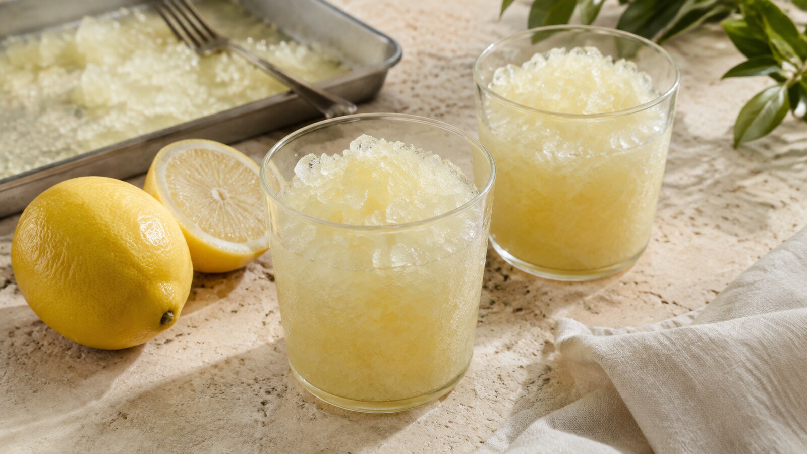 Vasos de granizado de limón con cristales finos y limones frescos