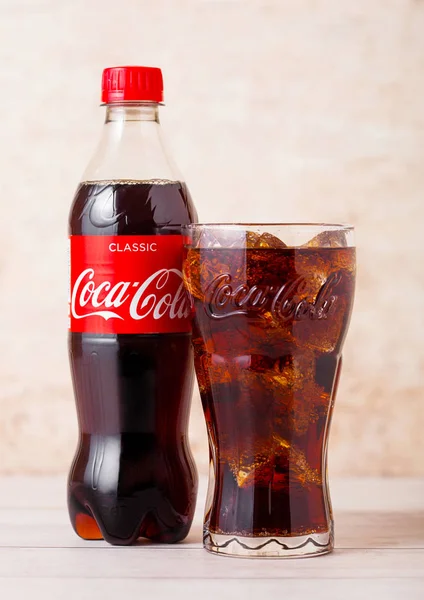 Refresco de cola servido frío en un vaso con hielo