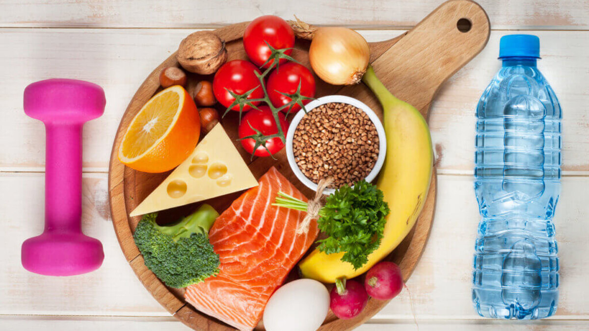 Comida de recuperación con arroz, verduras, proteína y agua después del ejercicio