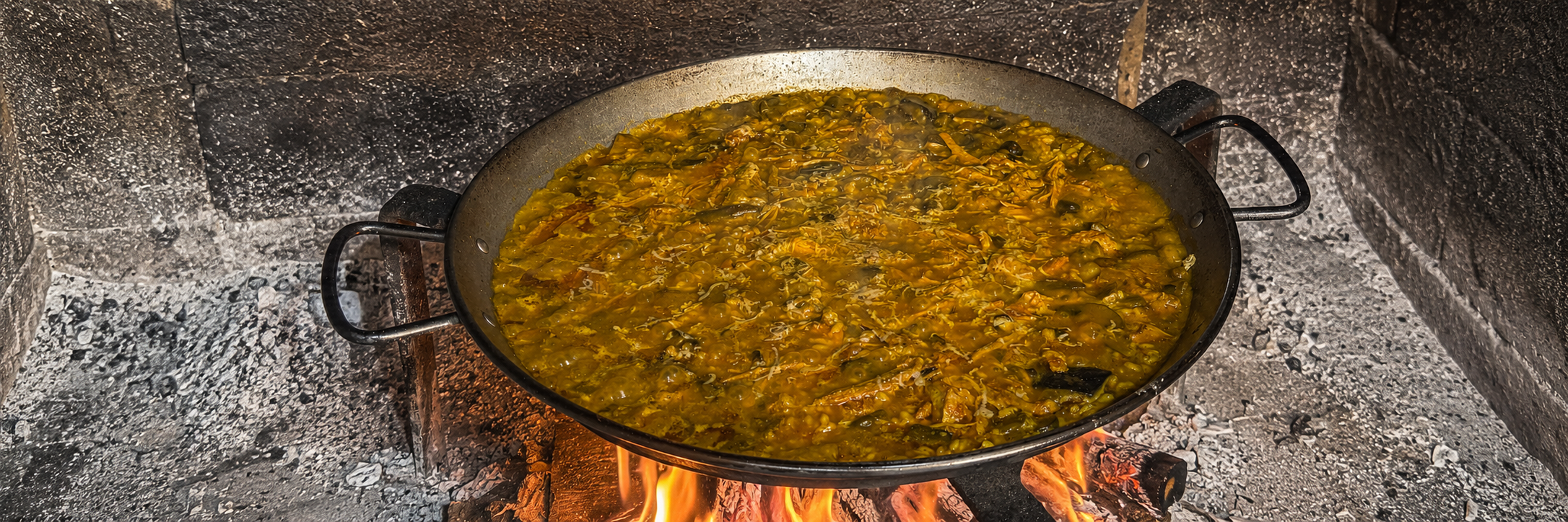Arroz seco de pulled pork, cebolla caramelizada y boletus servido en paella