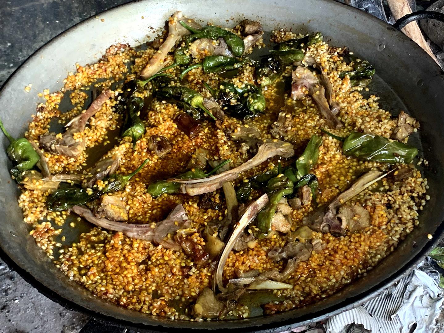 Paso 6 de la paella de cordero: rehogar el arroz para que se impregne del sofrito