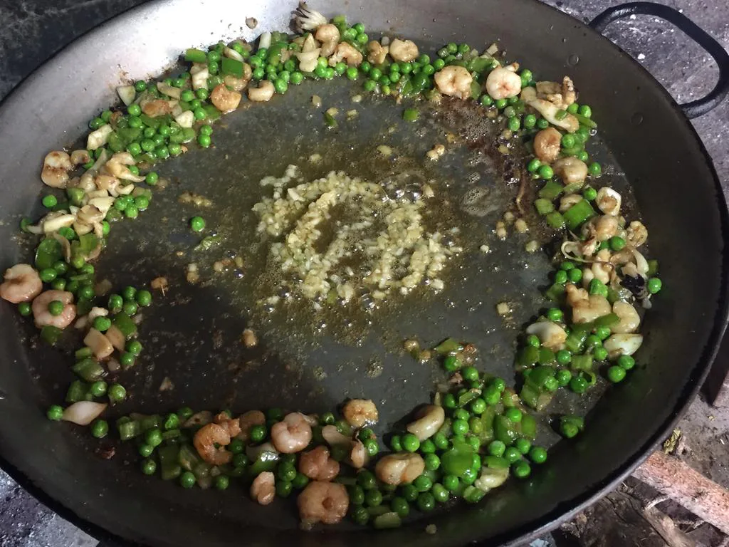 Detalle 2 del proceso de Paella de guisantes con pollo, blanquet, rape y marisco