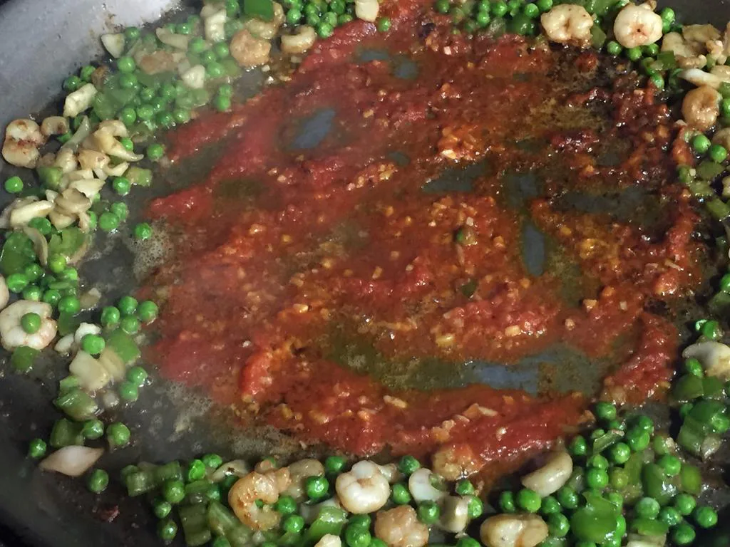 Detalle 3 del proceso de Paella de guisantes con pollo, blanquet, rape y marisco