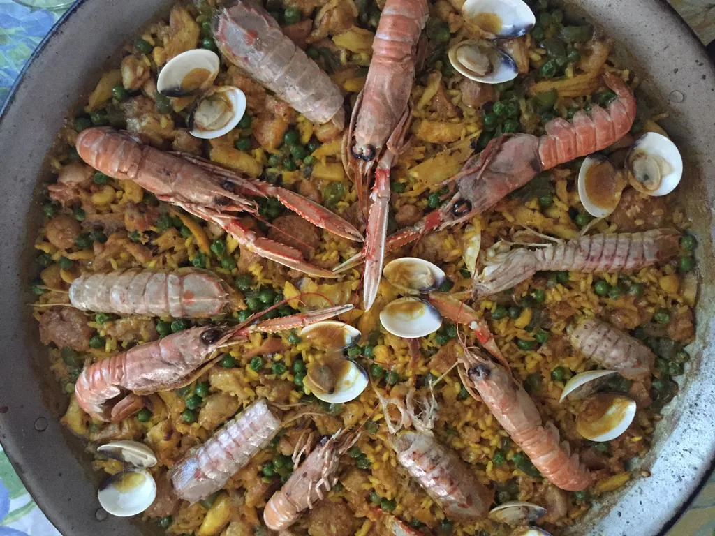 Paella de guisantes con pollo, blanquet, rape y marisco listo para servir