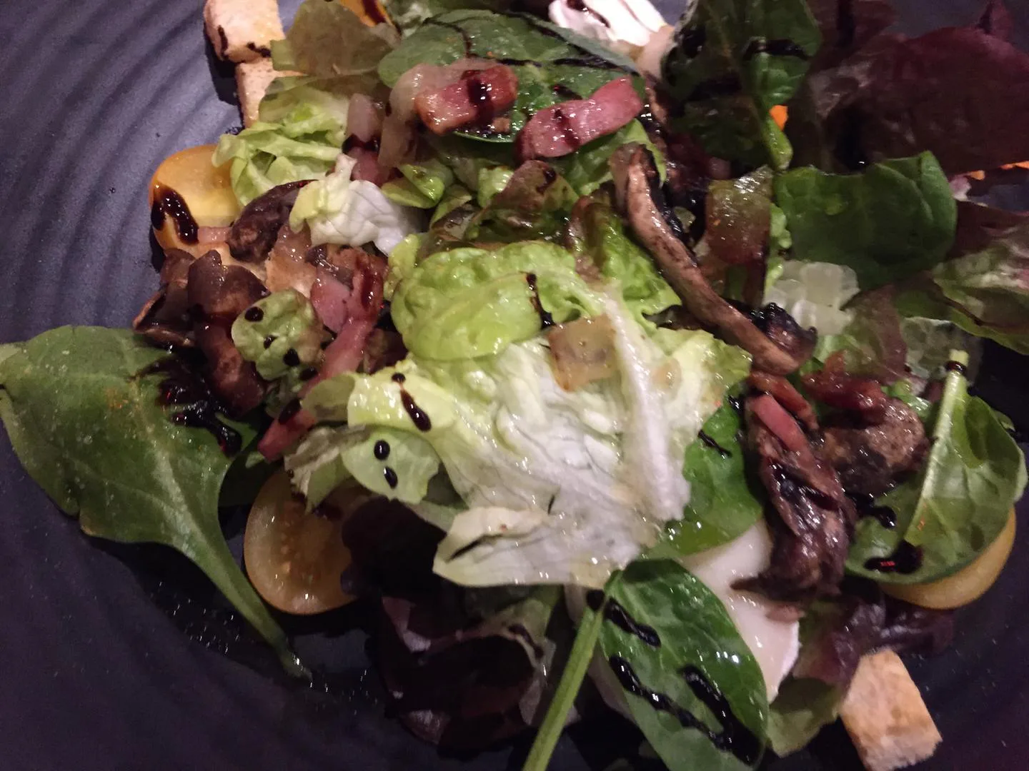 Ensalada templada de bacon y champiñones con hojas verdes lista para servir